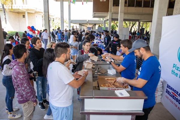 Students handing out pizzas to classmates